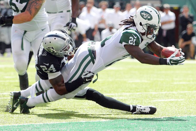Sep 7, 2014; East Rutherford, NJ, USA; New York Jets running back Chris Johnson (21) scores a touchdown past Oakland Raiders safety Charles Woodson (24) during the second quarter of a game at MetLife Stadium. Mandatory Credit: Brad Penner-USA TODAY Sports