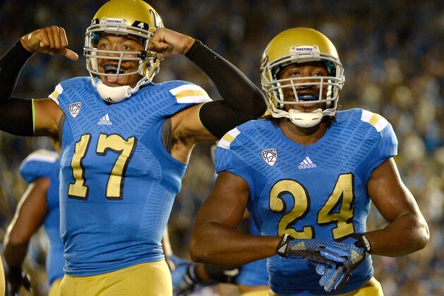 PASADENA, CA - SEPTEMBER 06:  Paul Perkins #24 and Brett Hundley #17 of the UCLA Bruins celebrate a 17 yard touchdown run to take a 6-0 lead over the Memphis Tigers during the first half at Rose Bowl on September 6, 2014 in Pasadena, California.  (Photo by Harry How/Getty Images)