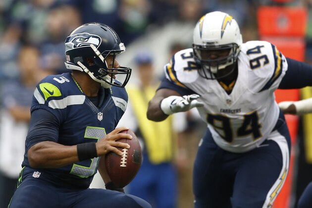 SEATTLE, WA - AUGUST 15: Quarterback Russell Wilson #3 of the Seattle Seahawks scrambles away from defensive end Corey Liuget #94 of the San Diego Chargers during the first quarter of the game at CenturyLink Field on August 15, 2014 in Seattle,Wa. (Photo by Otto Gruele/Getty Images)