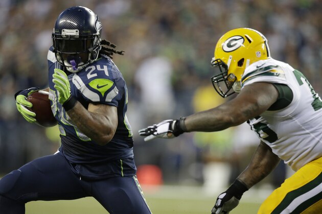 Seattle Seahawks running back Marshawn Lynch runs as defensive end Mike Daniels, right, pursues, in the second half of an NFL football game, Thursday, Sept. 4, 2014, in Seattle. (AP Photo/Scott Eklund)