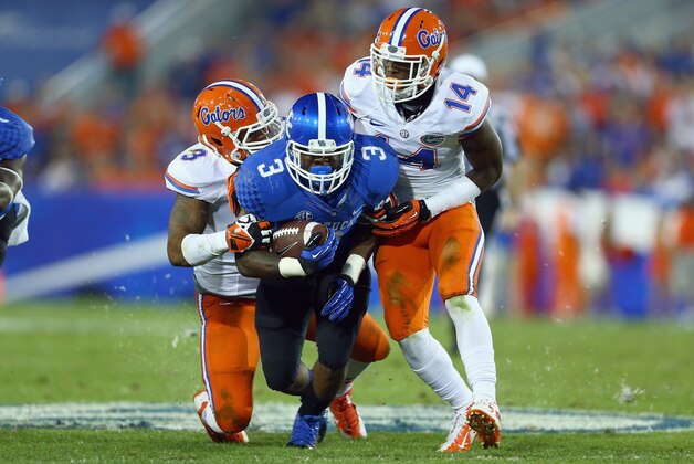 LEXINGTON, KY - SEPTEMBER 28:  Jojo Kemp #3 of the Kentucky Wildcats runs with the ball while tackled by Antonio Morrison #3 and Jaylen Watkins #14 of  the Florida Gators during the game at Commonwealth Stadium on September 28, 2013 in Lexington, Kentucky.  (Photo by Andy Lyons/Getty Images)