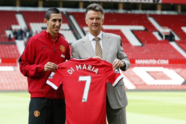 Manchester United's new player Angel Di Maria left, and manager Louis van Gaal, pose for photographers holding his new shirt, at Old Trafford Stadium in Manchester, England, Thursday, Aug. 28, 2014. Manchester United have signed winger Angel Di Maria from Real Madrid for a British record transfer fee of £59.7m. The Argentine winger had a medical in Manchester on Tuesday and has signed a five-year deal. (AP Photo/Alastair Grant)