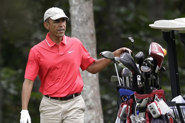 President Barack Obama selects a club while golfing at Farm Neck Golf Club, in Oak Bluffs, Mass., on the island of Martha's Vineyard, Saturday, Aug. 23, 2014. Obama is vacationing on the island. (AP Photo/Steven Senne)