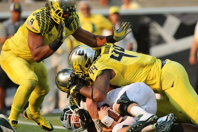 Michigan State's quarterback Conner Cook, bottom, ends up at the bottom of a pile of Oregon Ducks including Arik Armstead, left, Christian French and DeForest Buckner during the 3rd quarter of their college football game in Eugene, OR. Saturday Sept. 6, 2014. (AP Photo/Chris Pietsch)