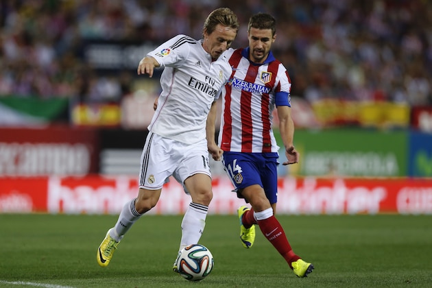 Real Madrid Luka Modric, left, duels for the ball with Atletico Madrid's Gabi during a Spanish Super Cup soccer match at the Vicente Calderon stadium in Madrid, Spain, Friday, Aug. 22, 2014. (AP Photo/Daniel Ochoa de Olza)