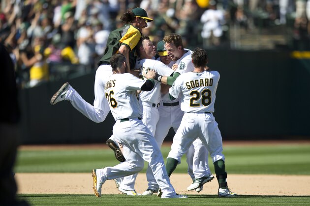 OAKLAND, CA - SEPTEMBER 06:  Jed Lowrie #8 of the Oakland Athletics is congratulated by teammates after hitting a walk off single against the Houston Astros during the ninth inning at O.co Coliseum on September 6, 2014 in Oakland, California. The Oakland Athletics defeated the Houston Astros 4-3.  (Photo by Jason O. Watson/Getty Images)