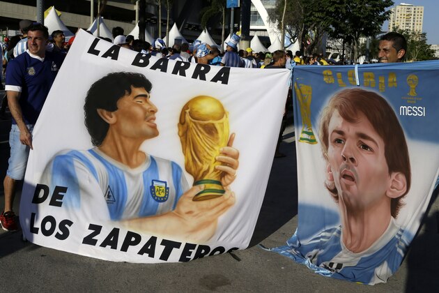 Argentinian fans hold banners with portraits of soccer legend Diego Armando Maradona, left, and Barcelona's soccer star Lionel Messi before the group F World Cup soccer match between Argentina and Bosnia in Rio de Janeiro, Brazil, Sunday, June 15, 2014. (AP Photo/Thanassis Stavrakis)