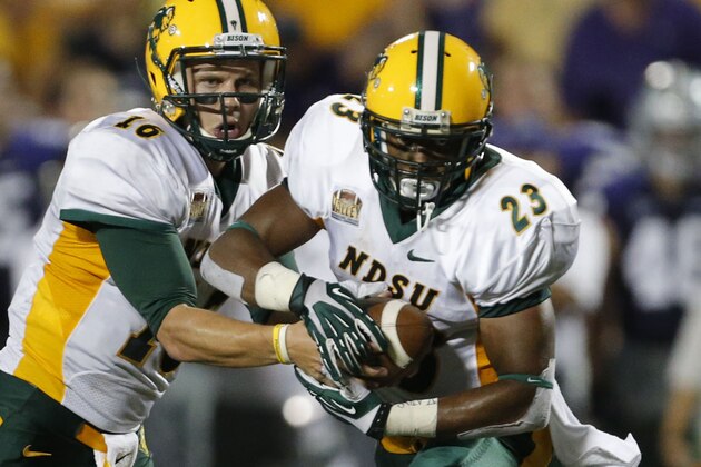 File - In this Aug. 30, 2013 file photo North Dakota State quarterback Brock Jensen (16) hands off to running back John Crockett (23) during an NCAA college football game against Kansas State in Manhattan, Kan. Crockett says he’s happy that  Bison head coach Craig Bohl is moving up and players have to understand the college football is a business. Bohl is leaving for Wyoming after the playoffs to take over the Cowboys. (AP Photo/Orlin Wagner, File)
