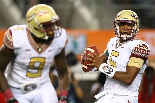 ARLINGTON, TX - AUGUST 30:  Jameis Winston #5 of the Florida State Seminoles looks to pass as Karlos Williams #9 flares out of the backfield against the Oklahoma State Cowboys in the first half of the Advocare Cowboys Classic at AT&T Stadium on August 30, 2014 in Arlington, Texas.  (Photo by Ronald Martinez/Getty Images)