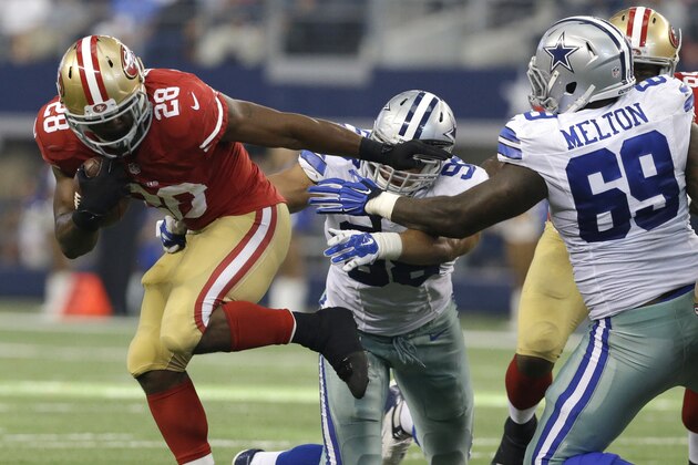 San Francisco 49ers running back Carlos Hyde (28) fights for extra yardage as Dallas Cowboys defensive tackle Henry Melton (69) and Tyrone Crawford (98) attempt the stop during the second half of an NFL football game, Sunday, Sept. 7, 2014, in Arlington, Texas. (AP Photo/LM Otero)