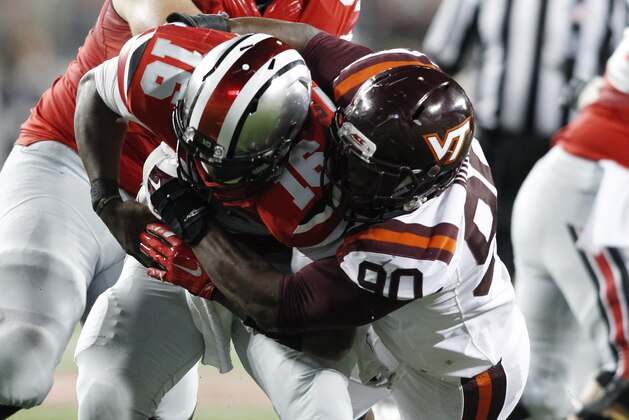 Virginia Tech defensive end Dadi Nicolas, right, sacks Ohio State quarterback J.T. Barrett during the fourth quarter of an NCAA college football game Saturday, Sept. 6, 2014, in Columbus, Ohio. Virginia Tech beat Ohio State 35-21. (AP Photo/Paul Vernon)