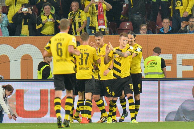 Dortmund's players celebrate after scoring during the soccer match between FC Augsburg and Borussia Dortmund in the SLG Arena in Augsburg, Germany, on Friday, Aug.  29, 2014. (AP Photo/Kerstin Joensson)
