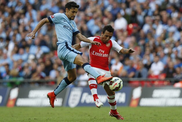 Arsenal's Santi Cazorla, right, competes for the ball with Manchester City's Jesus Navas during their English Community Shield soccer match at Wembley Stadium in London, Sunday, Aug. 10, 2014. (AP Photo/Sang Tan)