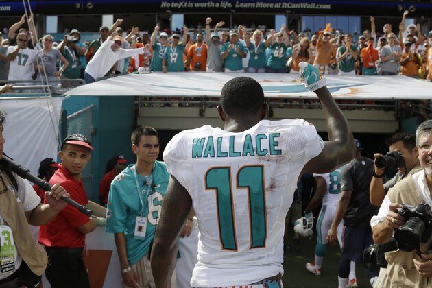 Miami Dolphins wide receiver Mike Wallace (11) waves to the fans as he walks off the field after the Dolphins defeated the New England Patriots 33-20 in the second half of an NFL football game, Sunday, Sept. 7, 2014, in Miami Gardens, Fla.  (AP Photo/Lynne Sladky)