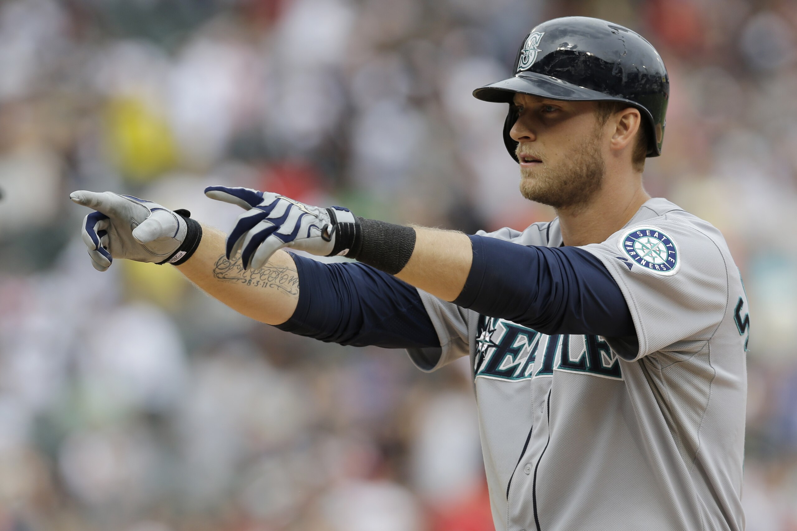 Seattle Mariners' Michael Saunders points to the dugout after hitting an one-run single during the ninth inning of a baseball game against the Chicago White Sox in Chicago on Saturday, July 5, 2014. (AP Photo/Nam Y. Huh)