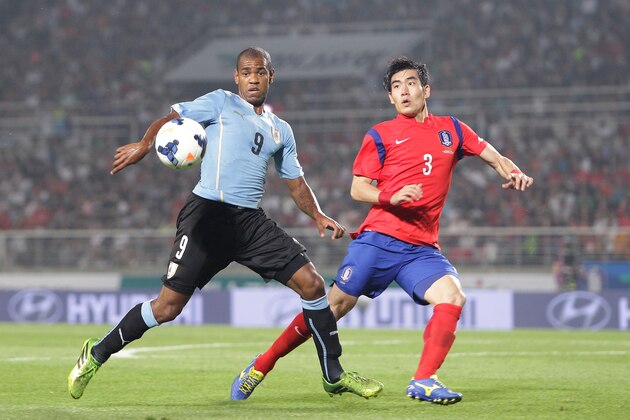 GOYANG, SOUTH KOREA - SEPTEMBER 08:  Diego Rolan of Uruguay competes for the ball with Kim Ju-Young of South Korea during the international friendly match between South Korea and Uruguay at Goyang Stadium on September 8, 2014 in Goyang, South Korea.  (Photo by Chung Sung-Jun/Getty Images)