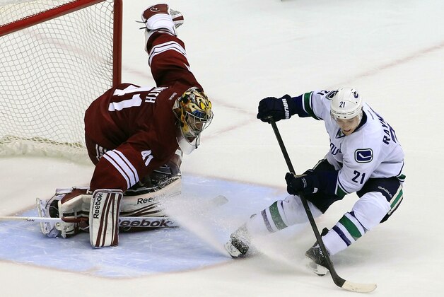 Phoenix Coyotes' Mike Smith (41) gets in front of the net as Vancouver Canucks' Mason Raymond (21) tries to spin in front of the net to get a shot off, that was eventually blocked, during the shootout in an NHL hockey game, Tuesday, Feb. 28, 2012, in Glendale, Ariz.  The Coyotes defeated the Canucks 2-1 in a shootout. (AP Photo/Ross D. Franklin)