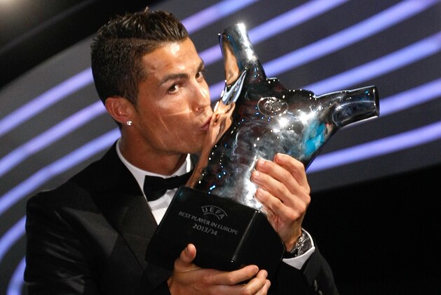 Named the best player of the year, Real Madrid Portuguese forward Cristiano Ronaldo, kisses his trophy during the UEFA Champions League draw, at the Grimaldi Forum, in Monaco, Thursday, Aug. 28, 2014. (AP Photo/Claude Paris)