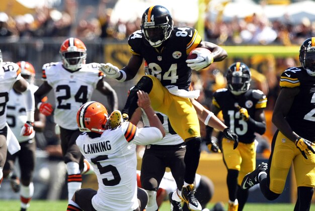 Sep 7, 2014; Pittsburgh, PA, USA; Pittsburgh Steelers wide receiver Antonio Brown (84) runs over Cleveland Browns punter Spencer Lanning (5) during the first half at Heinz Field. Brown was flagged on the play. Mandatory Credit: Jason Bridge-USA TODAY Sports