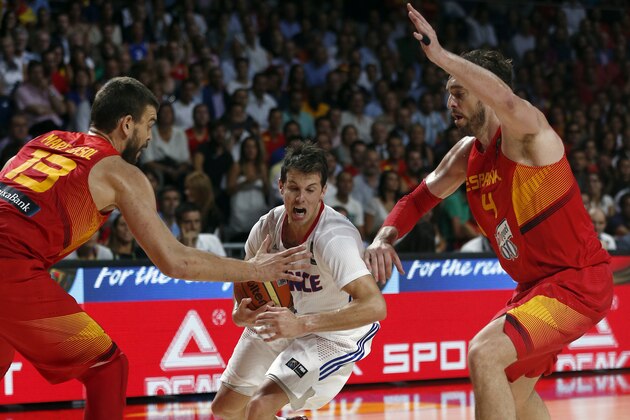 France's Thomas Heurtel, center, drives around Spain's Marc Gasol and Pau Gasol, right, during the basketball World Cup quarter finals match between Spain and France in Madrid, Spain, Wednesday, Sept. 10, 2014. The 2014 Basketball World Cup competition will take place in various cities in Spain from Aug. 30 through to Sept. 14. (AP Photo/Daniel Ochoa de Olza)