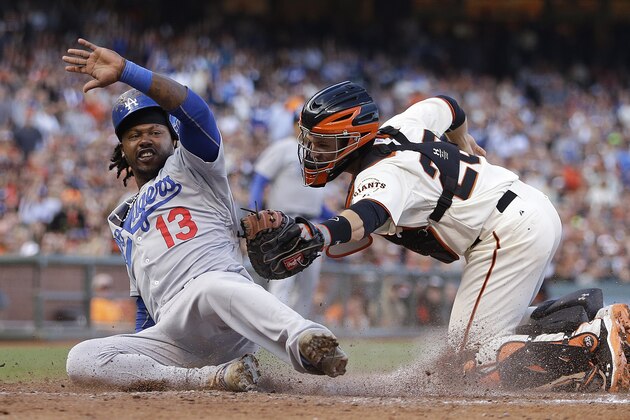 Los Angeles Dodgers' Hanley Ramirez, left, scores past San Francisco Giants catcher Buster Posey in the fifth inning of a baseball game Sunday, July 27, 2014, in San Francisco. Ramirez scored on a triple by Carl Crawford. (AP Photo/Ben Margot)