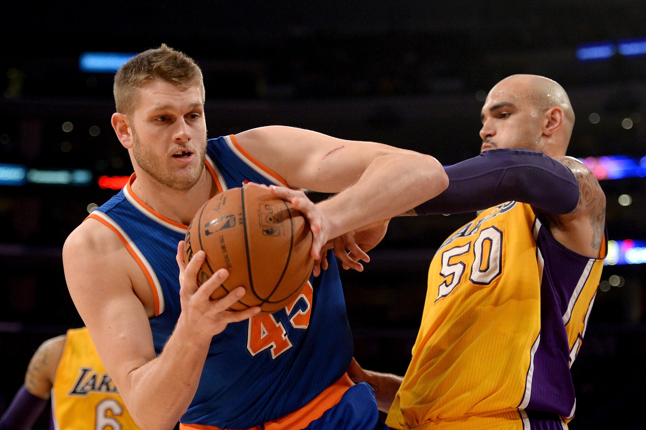 LOS ANGELES, CA - MARCH 25:  Cole Aldrich #45 of the New York Knicks grabs a rebound in front of Robert Sacre #50 of the Los Angeles Lakers at Staples Center on March 25, 2014 in Los Angeles, California.   NOTE TO USER: User expressly acknowledges and agrees that, by downloading and or using this Photograph, user is consenting to the terms and condition of the Getty Images License Agreement.  (Photo by Harry How/Getty Images)