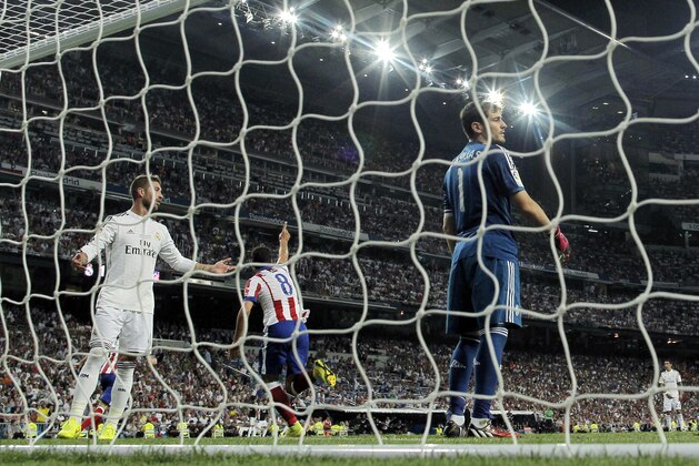 Atletico's Raul Garcia, center, celebrates his goal as Real Madrid's goalkeeper Iker Casillas, right, and Real's Sergio Ramos, left, react during a Spanish Supercup first leg soccer match at Santiago Bernabeu stadium in Madrid, Spain, Tuesday, Aug. 19, 2014. (AP Photo/Andres Kudacki)