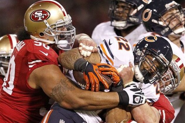 San Francisco 49ers defensive tackle Isaac Sopoaga (90) and defensive tackle Justin Smith tackle Chicago Bears running back Matt Forte (22) during the second half of an NFL football game in San Francisco, Monday, Nov. 19, 2012. (AP Photo/Tony Avelar)