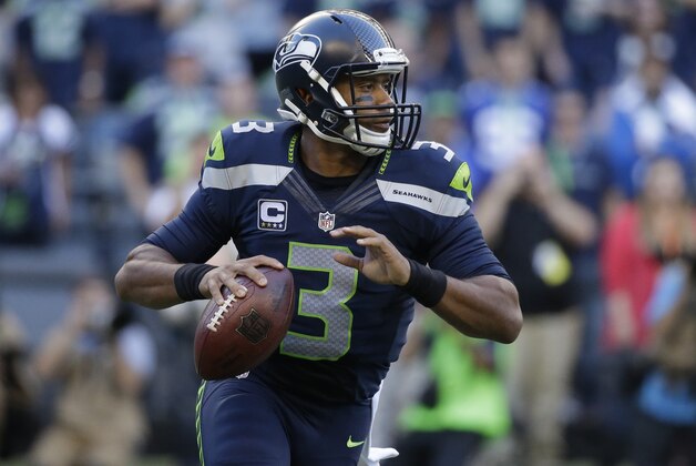 Seattle Seahawks quarterback Russell Wilson looks to pass in the first half of an NFL football game against the Green Bay Packers, Thursday, Sept. 4, 2014, in Seattle. (AP Photo/Elaine Thompson)