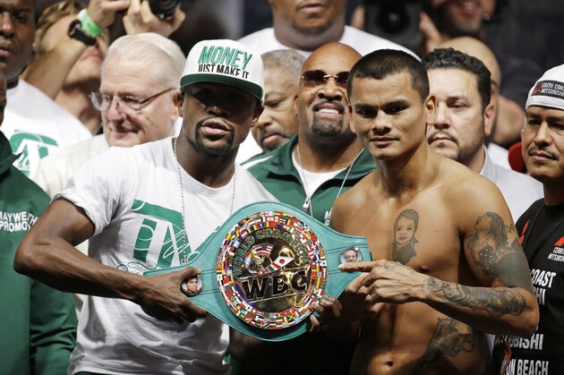 Floyd Mayweather Jr., left, and Marcos Maidana pose during a weigh-in Friday, Sept. 12, 2014, in Las Vegas. The two are scheduled to fight in a welterweight title bout Saturday in Las Vegas. (AP Photo/John Locher)