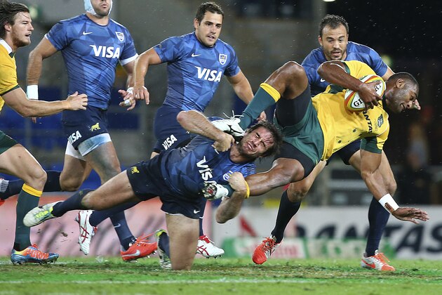 Australia's Tevita Kuridrani, right, is tackled by Argentina's Marcelo Bosch, left, during the Rugby Championship match on the Gold Coast, Australia, Saturday, Sept. 13, 2014. (AP Photo/Tertius Pickard)