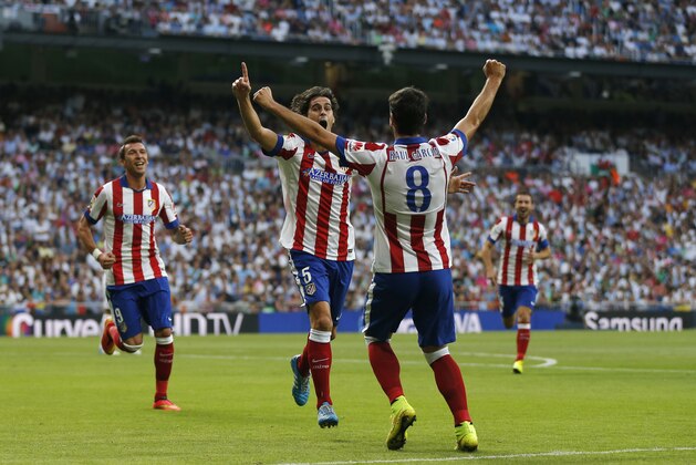 Atletico de Madrid’s Tiago from Portugal, center, celebrates after scoring a goal during a Spanish La Liga soccer match against Real Madrid at the Santiago Bernabeu stadium in Madrid, Spain, Saturday, Sept. 13, 2014. (AP Photo/Daniel Ochoa de Olza)