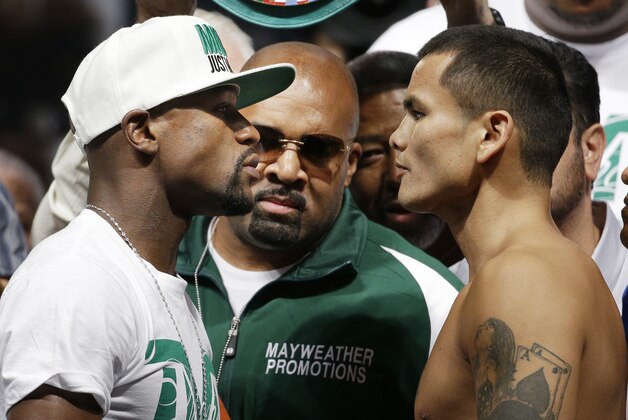 Floyd Mayweather Jr., left, and Marcos Maidana pose during a weigh-in Friday, Sept. 12, 2014, in Las Vegas. The two are scheduled to fight in a welterweight title boxing bout Saturday in Las Vegas. (AP Photo/John Locher)