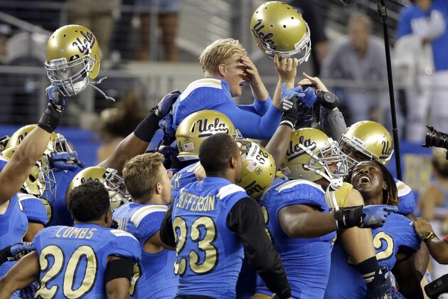 UCLA quarterback Jerry Neuheisel, top right, is carried off the field after UCLA's 20-17 win over Texas in an NCAA college football game, Saturday, Sept. 13,  2014, in Arlington, Texas. (AP Photo/Tony Gutierrez)