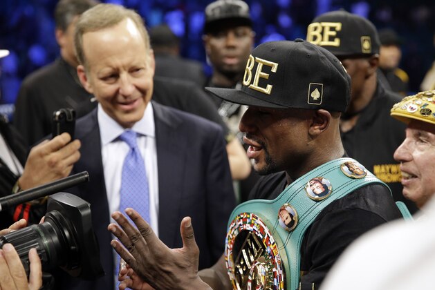 Floyd Mayweather shows the cameras his hand at the end of his fight against Marcos Maidana in a title boxing bout Saturday, Sept. 13, 2014, in Las Vegas. Mayweather claimed that Maidana bit his hand. (AP Photo/John Locher)