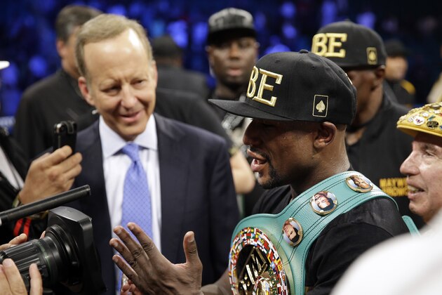 Floyd Mayweather shows the cameras his hand at the end of his fight against Marcos Maidana in a title boxing bout Saturday, Sept. 13, 2014, in Las Vegas. Mayweather claimed that Maidana bit his hand. (AP Photo/John Locher)