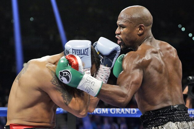 Floyd Mayweather punches Marcos Maidana, left, during their WBA welterweight and WBC super  welterweight title fight, Saturday, Sept. 13, 2014, in Las Vegas. (AP Photo/John Locher)
