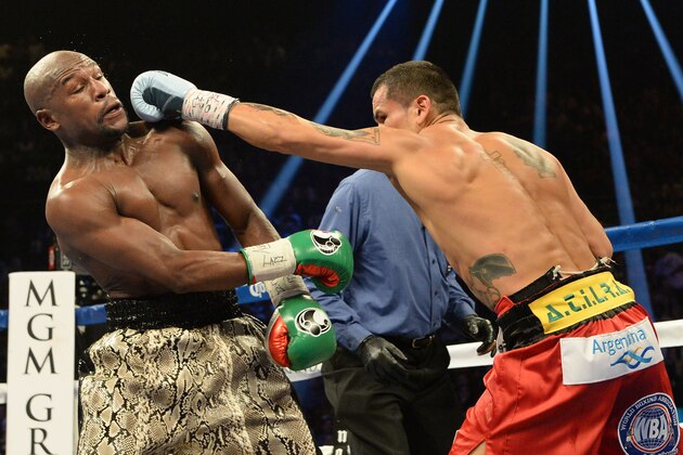 Sep 13, 2014; Las Vegas, NV, USA; Floyd Mayweather (green gloves) and Marcos Maidana (blue gloves) fight during their WBC & WBA Welterweight and WBC Superwelter Weight title bout at the MGM Grand Garden Arena. Mandatory Credit: Jayne Kamin-Oncea-USA TODAY Sports