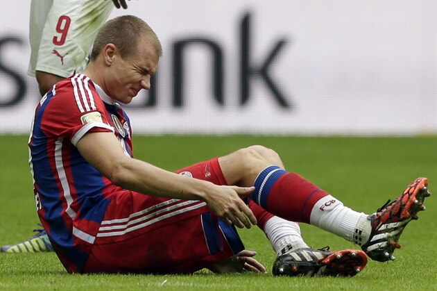 Bayern's Holger Badstuber sits injured on the ground during the soccer match between FC Bayern Munich and VfB Stuttgart in the Allianz Arena in Munich, Germany, on Saturday, Sept. 13, 2014. (AP Photo/Matthias Schrader)