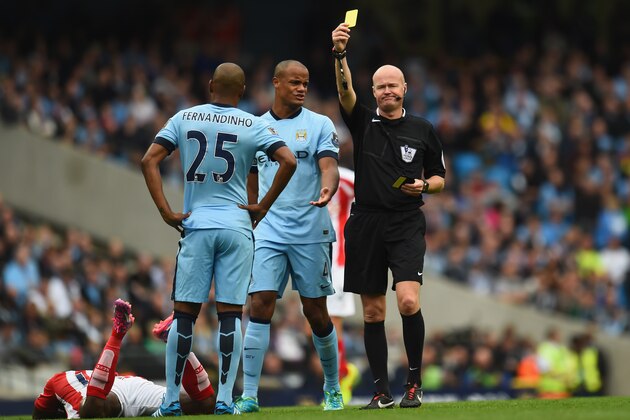 MANCHESTER, ENGLAND - AUGUST 30:  Referee Lee Mason shows Fernandinho of Manchester City a yellow card during the end of the Barclays Premier League between Manchester City and Stoke City at Etihad Stadium on August 30, 2014 in Manchester, England.  (Photo by Shaun Botterill/Getty Images)