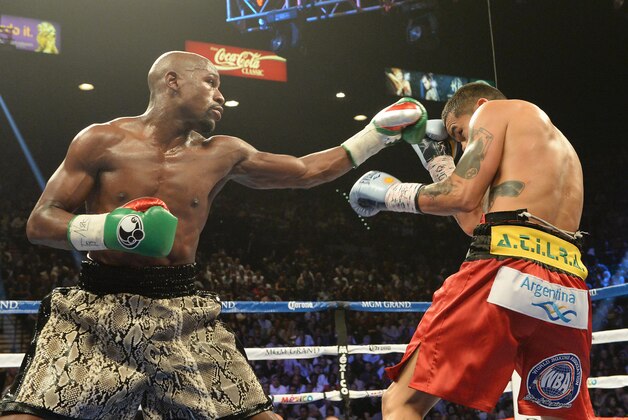 Sep 13, 2014; Las Vegas, NV, USA; Floyd Mayweather (green gloves) and Marcos Maidana (blue gloves) trade punches during their WBC & WBA Welterweight and WBC Superwelter Weight title fight at the MGM Grand Garden Arena. Mandatory Credit: Jayne Kamin-Oncea-USA TODAY Sports