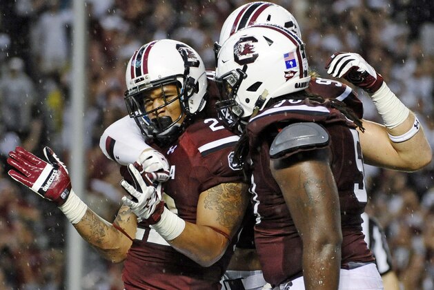 South Carolina running back Brandon Wilds (22) celebrates with teammates Cody Gibson (90) and A.J. Cann (50) after scoring a touchdown during the second half of an NCAA college football game on Saturday, Sept. 13, 2014, in Columbia, S.C. (AP Photo/Rainier Ehrhardt)