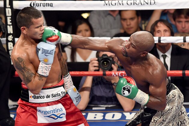 LAS VEGAS, NV - SEPTEMBER 13:  (R-L) Floyd Mayweather Jr. throws a right to the face of Marcos Maidana during their WBC/WBA welterweight title fight at the MGM Grand Garden Arena on September 13, 2014 in Las Vegas, Nevada.  (Photo by Ethan Miller/Getty Images)
