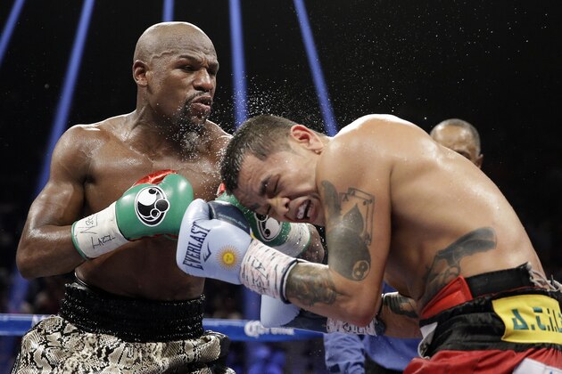 Floyd Mayweather punches Marcos Maidana, right, during their WBA welterweight and WBC super  welterweight title fight, Saturday, Sept. 13, 2014, in Las Vegas. (AP Photo/John Locher)