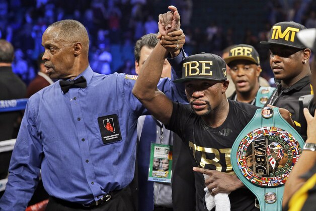 Floyd Mayweather shows off his belts after beating Marcos Maidana during their WBA welterweight and WBC super  welterweight title fight, Saturday, Sept. 13, 2014, in Las Vegas. (AP Photo/John Locher)
