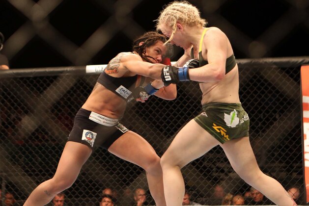 Jul 16, 2014; Atlantic City, NJ, USA;  Claudia Gadelha (red gloves) exchanges punches with Tina Lahdemaki (blue gloves) during a 115-pound women's division bout at Revel Casino. Mandatory Credit: Bill Streicher-USA TODAY Sports