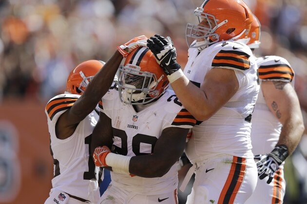 Cleveland Browns running back Terrance West is mobbed by teammates after a 9-yard touchdown run -as- in the third quarter of an NFL football game Sunday, Sept. 14, 2014, in Cleveland. (AP Photo/Tony Dejak)