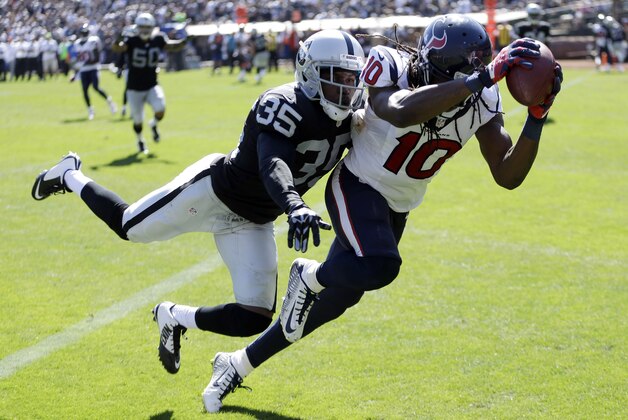 Houston Texans wide receiver DeAndre Hopkins, right, hauls in a 12-yard pass for a touchdown as Oakland Raiders defensive back Chimdi Chekwa, left, makes the tackle in the third quarter of an NFL football game Sunday, Sept. 14, 2014, in Oakland, Calif. (AP Photo/Ben Margot)
