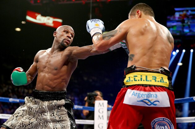 LAS VEGAS, NV - SEPTEMBER 13:  (L-R) Floyd Mayweather Jr. throws a left to the face of Marcos Maidana during their WBC/WBA welterweight title fight at the MGM Grand Garden Arena on September 13, 2014 in Las Vegas, Nevada.  (Photo by Al Bello/Getty Images)