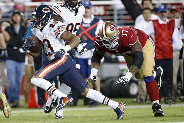 Chicago Bears cornerback Kyle Fuller (23) returns an interception past San Francisco 49ers guard Mike Iupati (77) during the fourth quarter of an NFL football game in Santa Clara, Calif., Sunday, Sept. 14, 2014. (AP Photo/Tony Avelar)